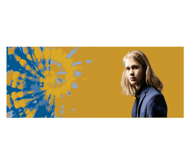 A person with long hair wearing a blue jacket stands confidently against a backdrop featuring blue and yellow paint splatters on the left and a solid mustard color on the right, embodying the spirit of DiversAbility advocacy.
